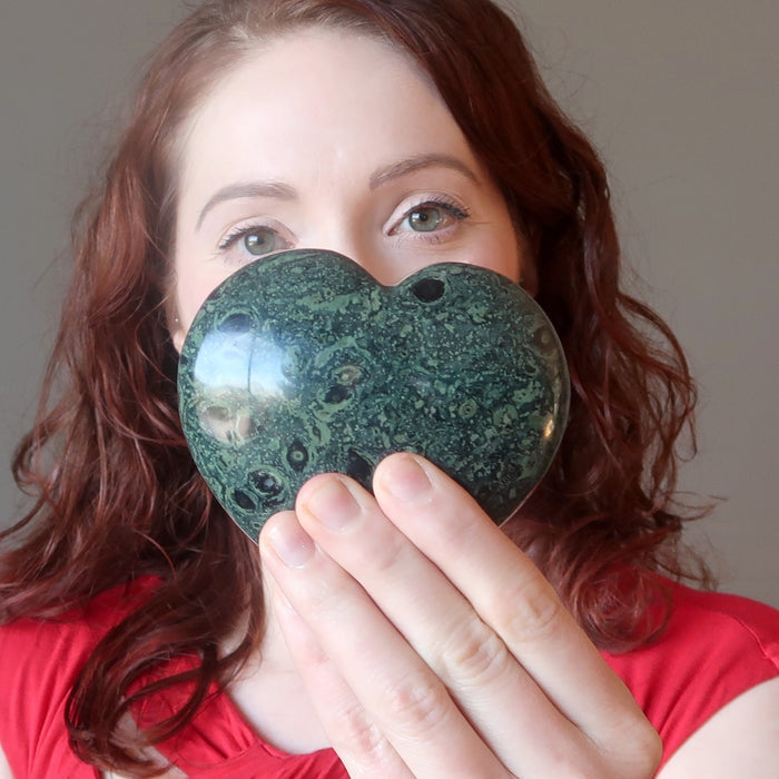 woman holding up kambaba jasper heart