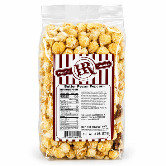 A 8 oz bag of Poppin' HR Snacks Butter Pecan Popcorn, showing the clear plastic packaging filled with golden-brown caramel popcorn and a red and white striped label on a white background.