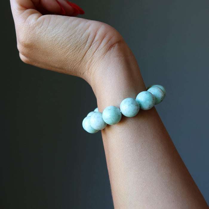Green Chrysoprase beaded bracelet  on a wrist against a dark background