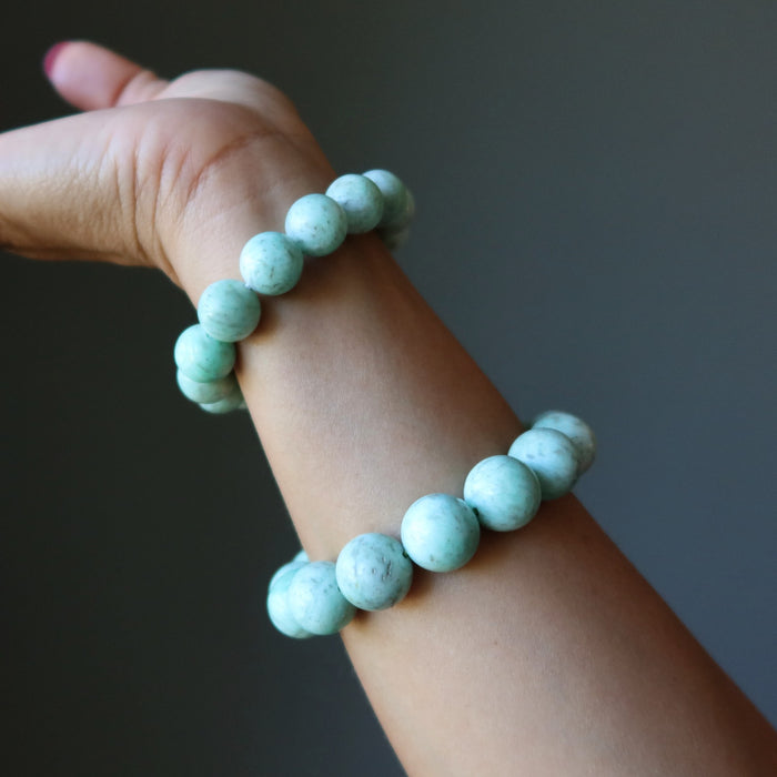 Green Chrysoprase beaded bracelet  on a wrist against a dark background