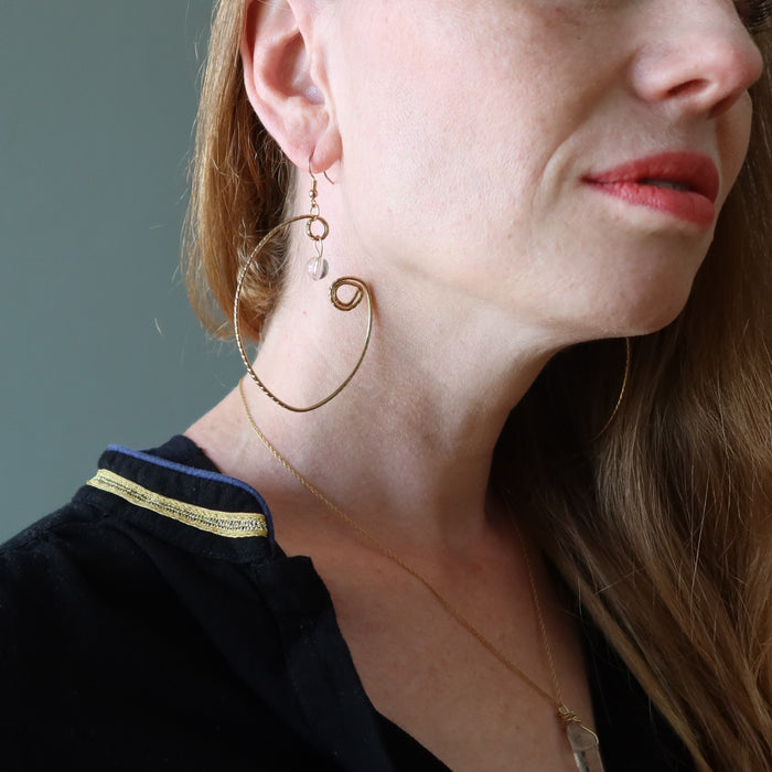 female model wearing Clear Quartz Wrap of Curved Gold Hoop Earrings