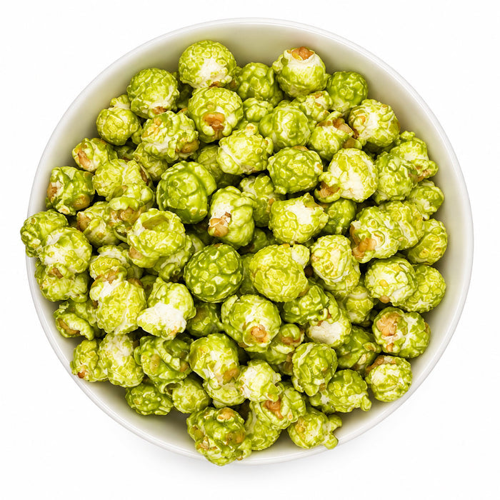 Green popcorn coated in white sauce, served in a white bowl on a white background.