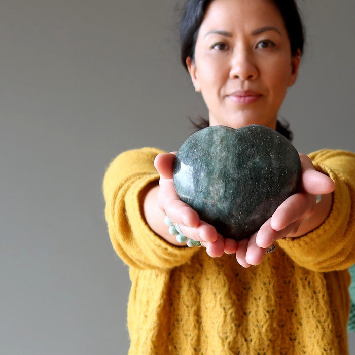 woman holding dark green aventurine hearts