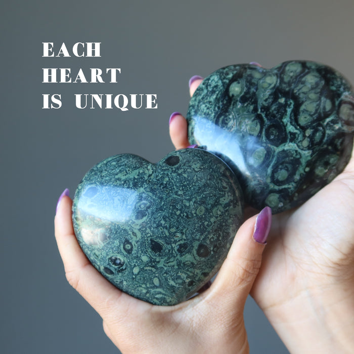 hands holding two kambaba jasper heart
