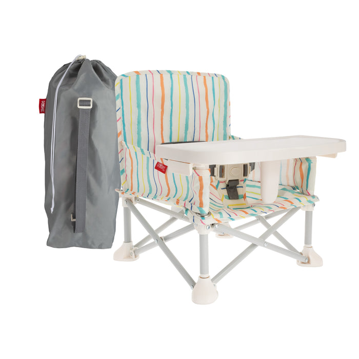 The Nuby Pop Up Booster Seat | Stripes features colorful striped fabric, a white tray, and safety harness. Shown with a gray carry bag, its foldable frame makes this portable high chair perfect for travel.