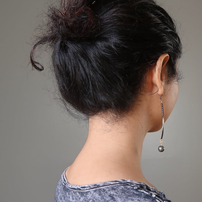 sheila of satin crystals wearing faceted pyrite on long curved earrings