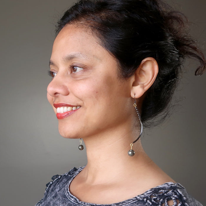 sheila of satin crystals wearing faceted pyrite on long curved earrings