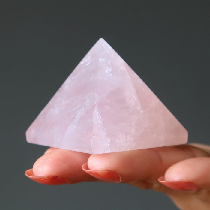 hand holding pink rose quartz pyramid