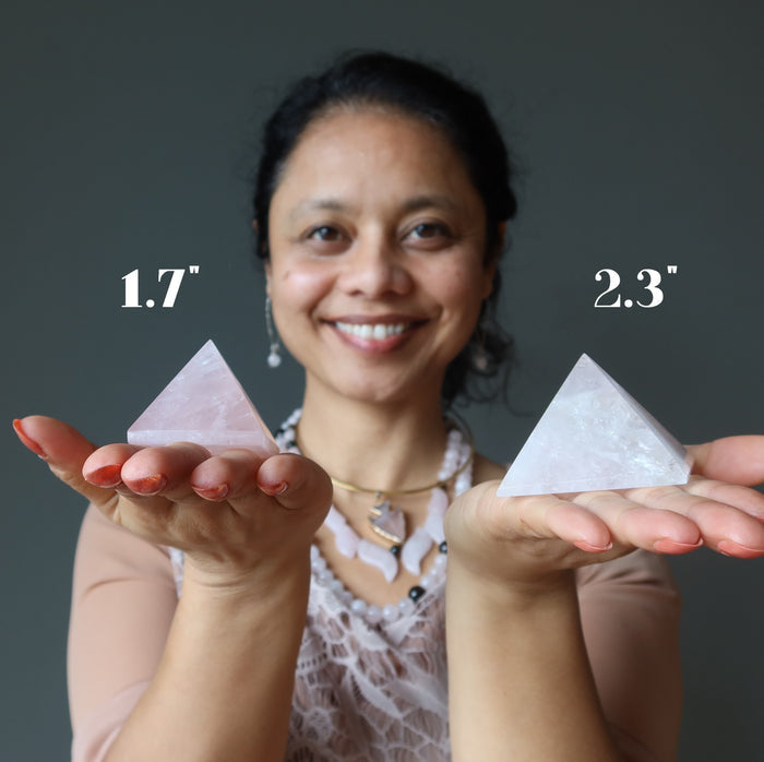 sheila of satin crystals holding two rose quartz pyramids to show size difference
